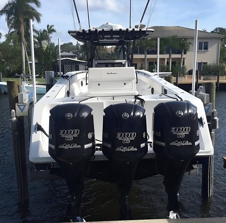 Triple Yamaha 300 V6 center console on boat lift, rear view — South Florida canal by Contour Marine