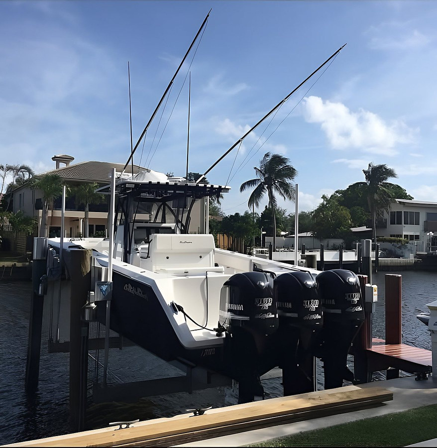 Triple-engine center console on boat lift, side view — South Florida waterfront by Contour Marine