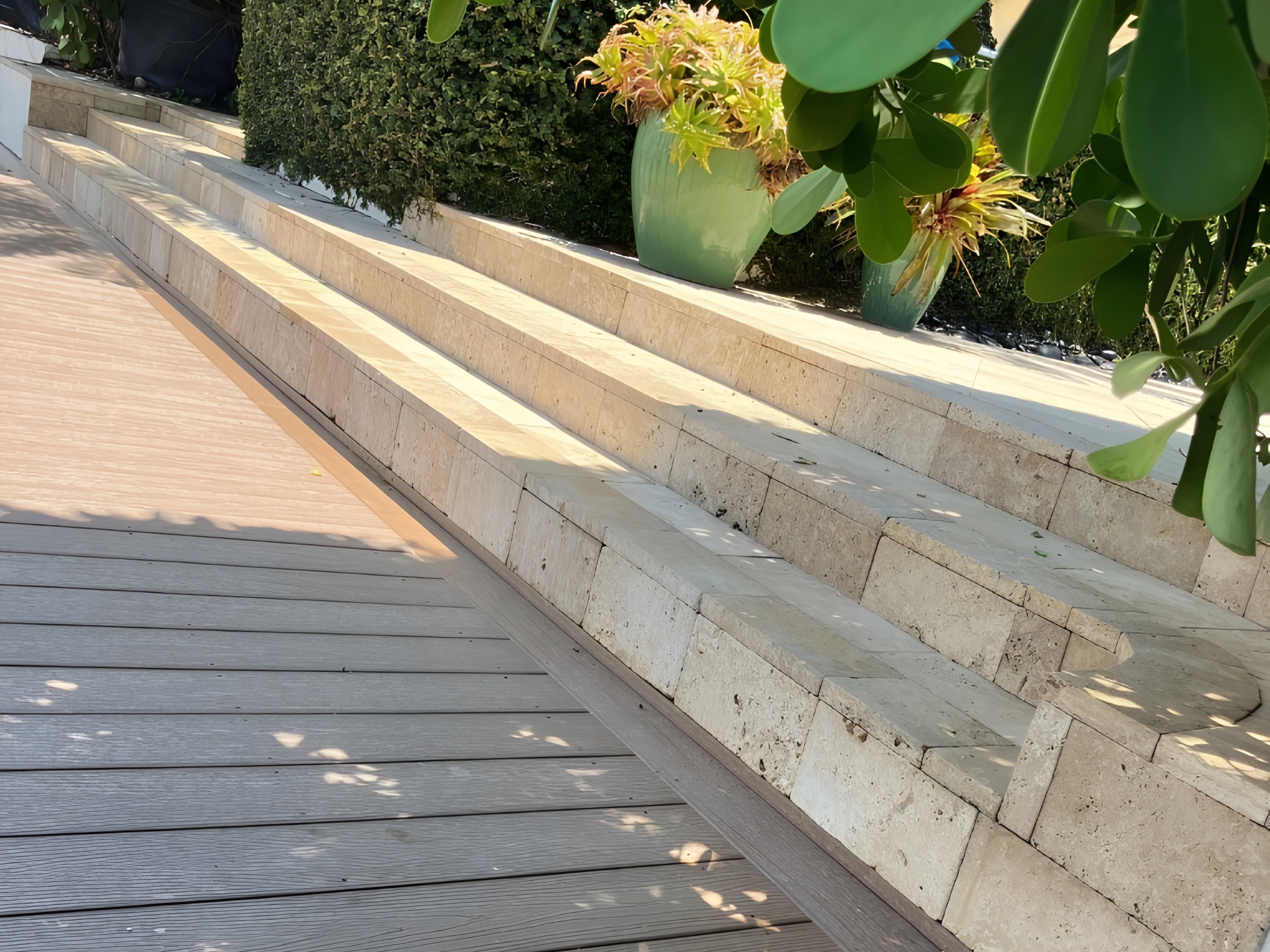 Composite deck with travertine stone steps and tropical landscaping — South Florida by Contour Marine