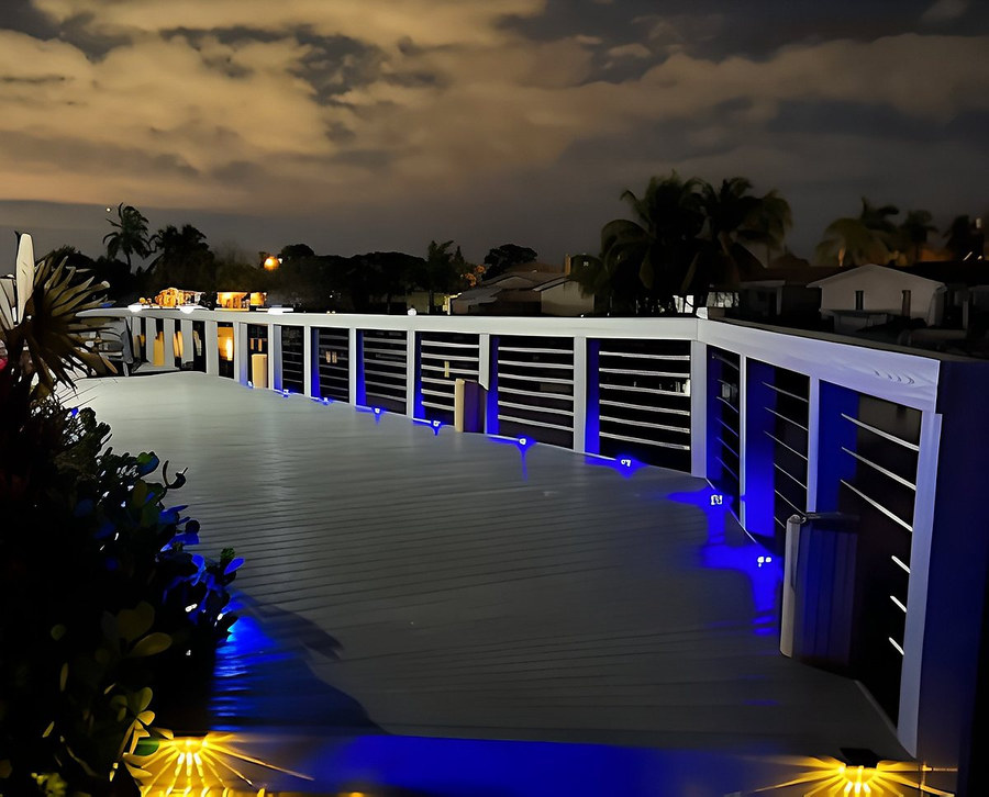 Illuminated waterfront deck at night with blue LED rail accent lights — South Florida by Contour Marine