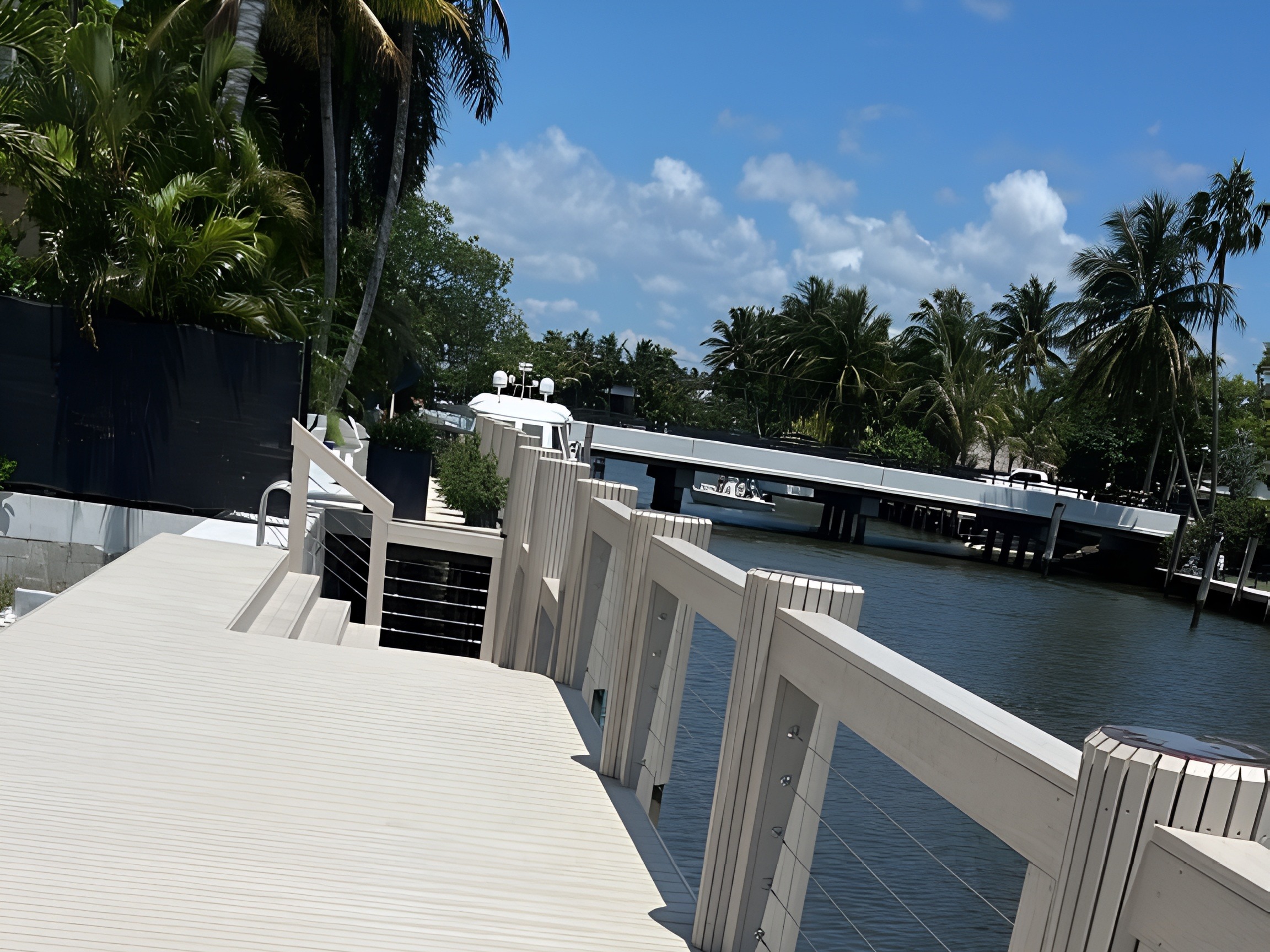 Grey composite dock with stainless steel cable railing system along South Florida canal — Contour Marine