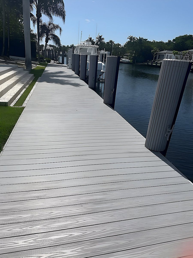 Gray composite dock walkway with dark pilings along a South Florida canal — Contour Marine