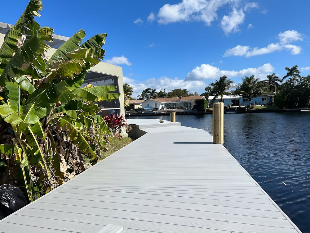 Beige composite dock with square posts lining a South Florida canal waterfront — Contour Marine