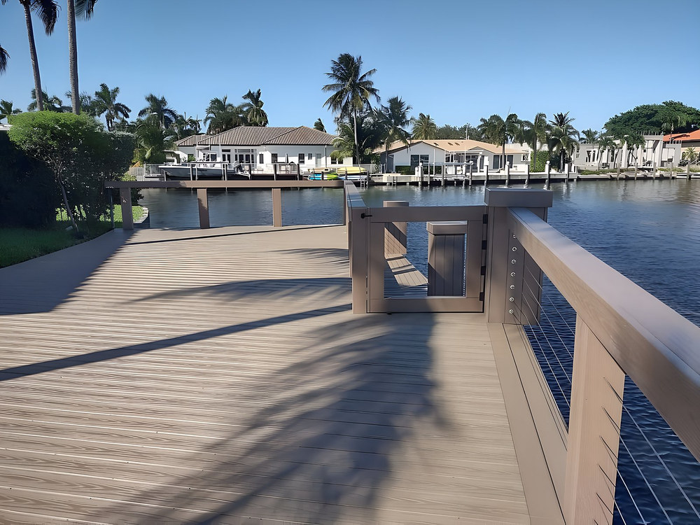Grey composite dock with stainless cable railing and gate — South Florida canal