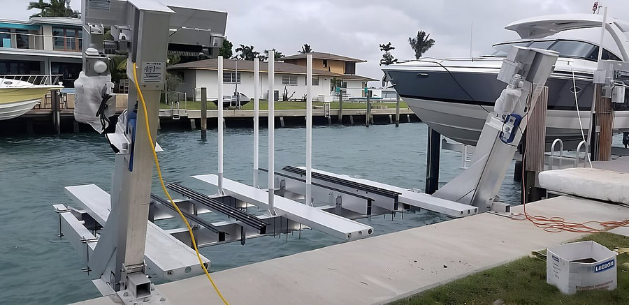 Deco double jet ski lift cradles and large yacht alongside — wide canal view South Florida