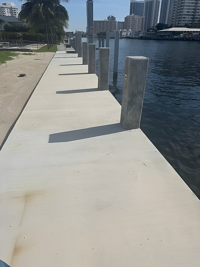Completed concrete seawall cap with square marine pilings — South Florida